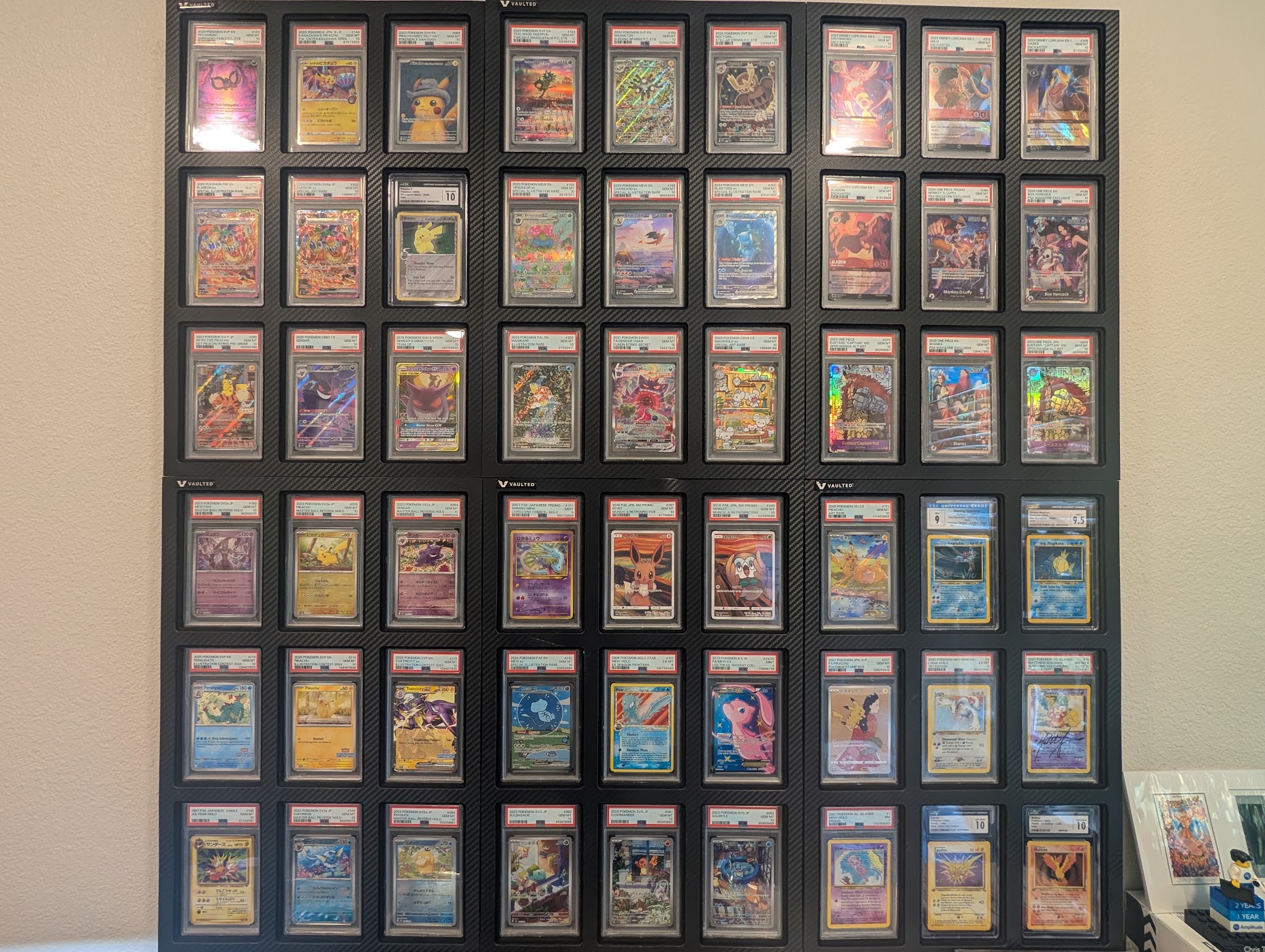 Wall display of graded Pokémon, Lorcana, and One Piece trading cards